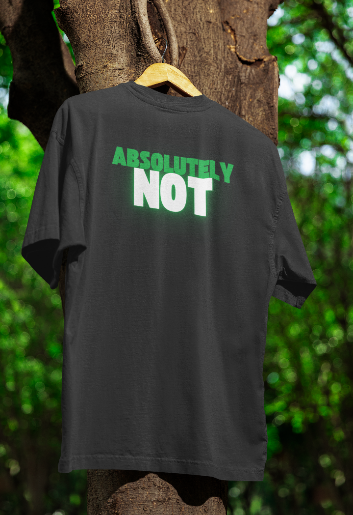 Black t-shirt hanging on a wooden hanger outdoors, featuring "ABSOLUTELY NOT" in bold green and white text with a glow effect. The shirt is displayed against a tree with green foliage in the background.