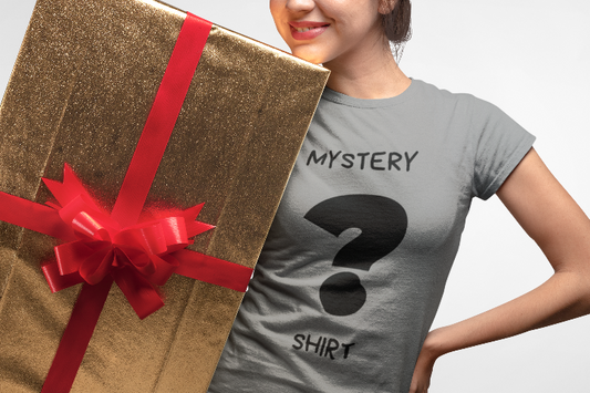 girl in a grey t shirt holding a large wrapped gift box, the shirt says mystery shirt with question mark