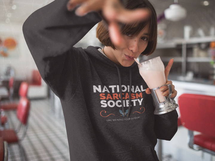 model is wearing a black hoodie that says national sarcasm society like we need your support