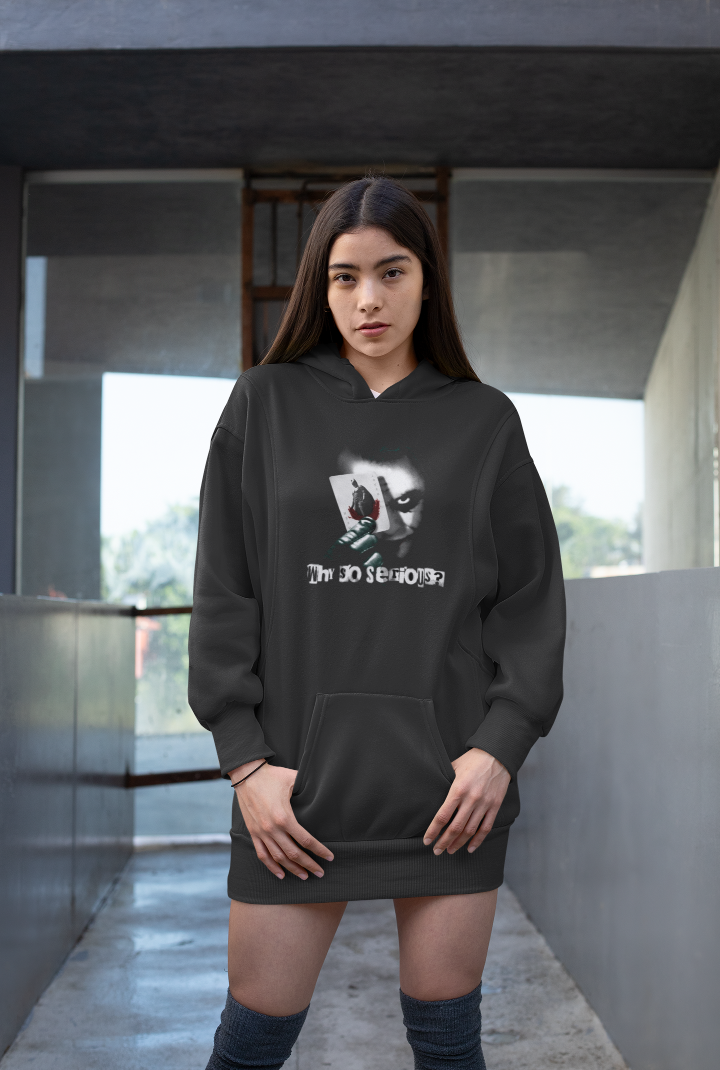 model is wearing a black hoodie that has a graphic of the joker holding a playing card and the words why so serious?