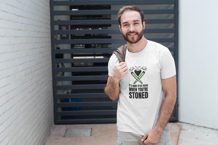 a man wearing a white tshirt with a graphic of two joints and the words it's hard to be mean when you're stoned